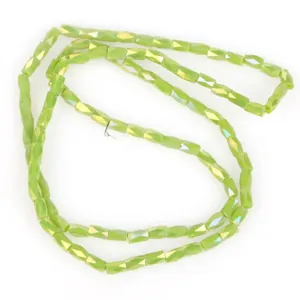 Macro view of 2x4mm faceted light green iridescent glass beads for jewelry making