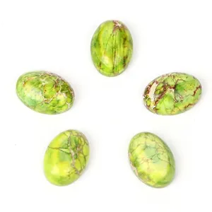 Gros plan sur de petites pierres ovales de turquoise impériale verte de 10x14mm