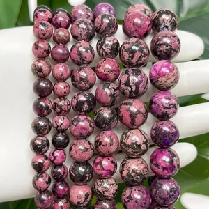 Close-up detail showing the natural mottled texture of pink and black snowflake turquoise beads