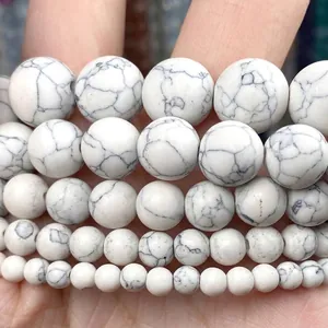 Gros plan de perles rondes en howlite blanche naturelle avec veines grises pour bijoux