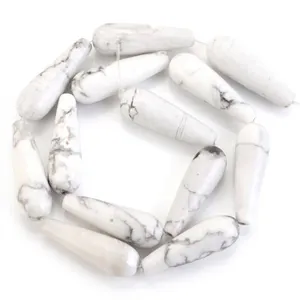Gros plan de perles gouttes en howlite blanche naturelle avec veines grises pour bijoux.