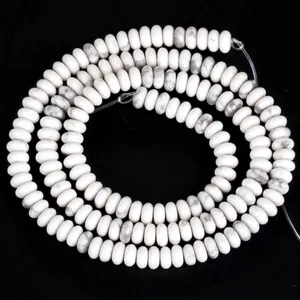 Vue macro de perles de howlite blanche naturelle avec veines grises pour création de bijoux
