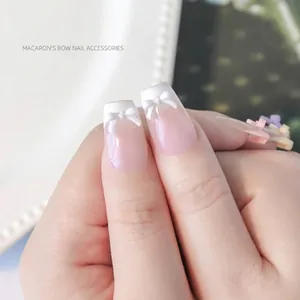 Mini-hars macaron strikjes nageldecoraties op professionele wit getipte gemanicuurde nagels