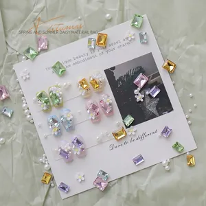 Exquisite DIY nail art material kit with green crystals, white daisy charms and pearls.