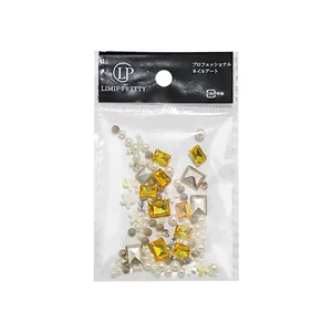 Professional nail art accessory set with yellow rhinestones, pearls and flower charms