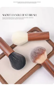 Close-up detail of three soft nail dust brushes with walnut-style handles on wooden tray