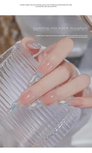 Primo piano di diamanti per unghie in acrilico color proteina su unghie molto lunghe.