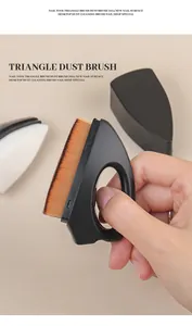 Close-up of black triangle nail dust brush with finger-buckle handle for professional use.