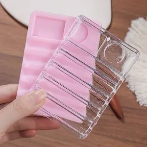 Multifunctional clear and pink nail brush holder with palette for manicure organization.