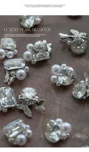 Macro detail of sparkling rhinestones and white pearls for luxury nail art designs.