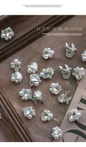 Close-up of luxury pearl and diamond nail art accessories with butterfly metal charms