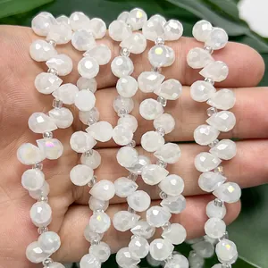 Vista de detalle de cuentas de gota facetadas blancas e iridiscentes de 6mm para joyas DIY