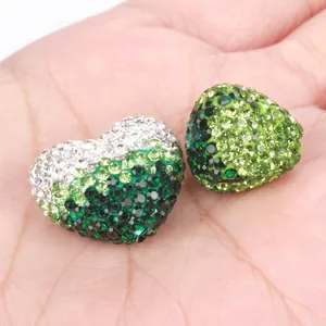 Macro dettagli di perle Shamballa a forma di cuore con strass verdi e bianchi