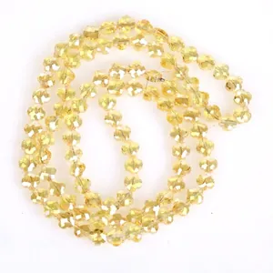 Detaillierte Makroansicht von facettierten gelben Blumen-Glaskristallperlen für DIY-Schmuck