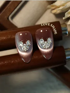 Gedetailleerde opname van een hartvormige strass-collage op cat-eye nagelkunst