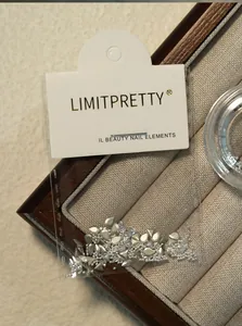 Close-up van zilveren druppelvormige nagelsteentjes in de LIMITPRETTY-verpakking