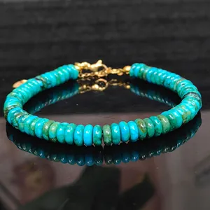 Detailed macro view of a turquoise Phoenix pine disc bead bracelet with golden clasp.