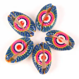 Detailed macro view of colorful printed cowrie shell beads with eye patterns for DIY