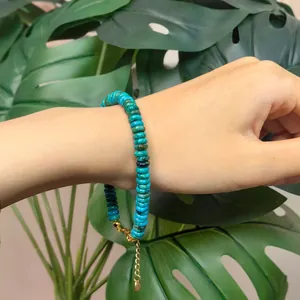 Macro view of handmade turquoise disc bead bracelet with gold lobster clasp