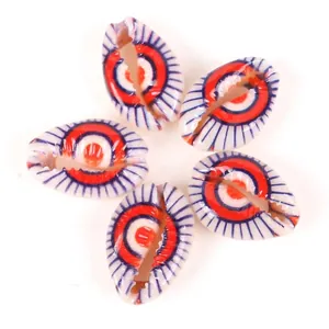 Detailed view of five printed cowrie shells with eye pattern for DIY jewelry making.
