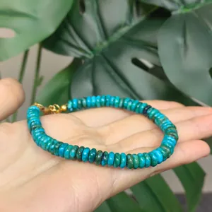 Close-up of handmade Phoenix Pine turquoise disc bead bracelet with gold clasp