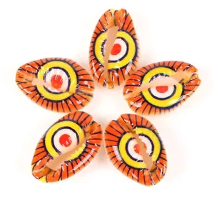 Detailed close-up view of evil eye patterned cowrie shell beads for DIY jewelry making.