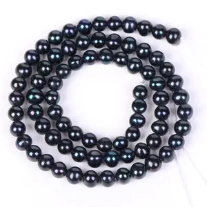 Gros plan de perles noires semi-rondes avec éclat iridescent pour bijoux DIY