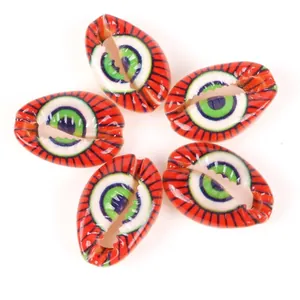 Close-up macro view of printed evil eye pattern on cowrie shell beads for DIY jewelry