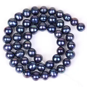 Détail macro de perles noires presque rondes et brillantes pour bijoux artisanaux