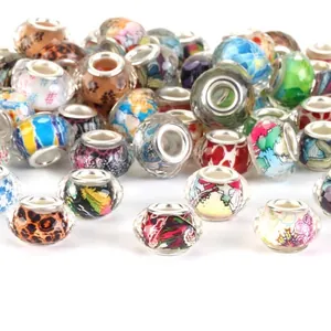 Close-up of mixed colorful large hole beads with faceted patterns for DIY jewelry making.