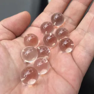 Macro-weergave van kristalheldere Braziliaanse witte kristallen bollen in een hand