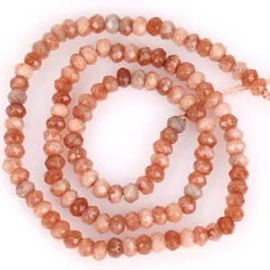Nahaufnahme von facettierten 3x4mm pfirsichfarbenen Natursteinhöhlen für DIY-Schmuck