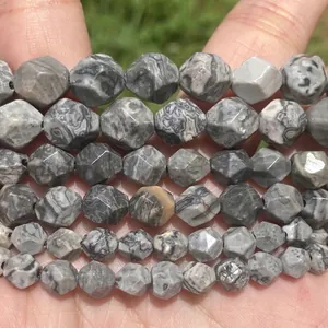 Close-up of faceted natural stone beads with grey marble patterns for DIY jewelry.