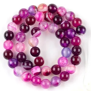 Macro view of rose red natural chalcedony loose beads with unique banded patterns