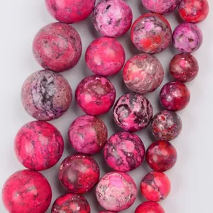 Close-up detail of magenta natural stone chalcedony beads showing marbled texture