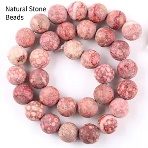 High-quality close-up detail of rose red natural stone beads with unique spotted patterns