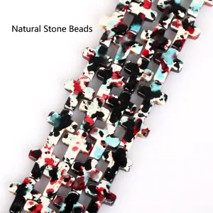 Macro detail of camouflage patterned turquoise cross beads for creative DIY jewelry craft