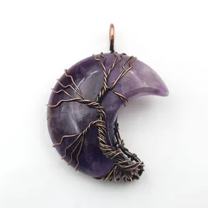 Detail of a handmade amethyst crescent moon pendant with a copper tree of life wire wrap