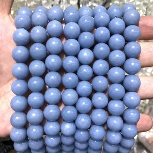 Detailed view of smooth round angelite blue stone beads for DIY jewelry creations.