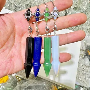 Detail view of four vibrant crystal pendulums with silver hexagram charms held in hand