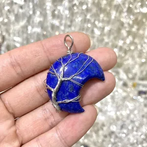 Detailed view of wire-wrapped tree of life on blue lapis lazuli crescent moon pendant