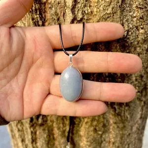 Close-up detail of a natural blue angelite oval stone pendant with a silver bezel