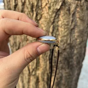 Detailed close-up view showing the side profile of an oval blue angelite stone pendant