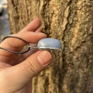 Detailed side view of a natural blue angel stone oval pendant with silver base