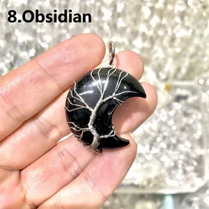 Detailed view of handmade black obsidian moon pendant with silver wire-wrapped tree of life.