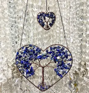 Macro detail of Tree of Life heart pendants featuring intricate wire wrapping and blue gems