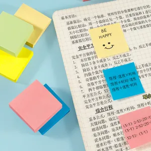 Primer plano de notas adhesivas cuadradas de colores en un cuaderno