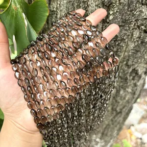 Detalle macro de cuentas de cuarzo ahumado natural en forma ovalada plana para DIY