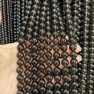 Primer plano de cuentas redondas de cuarzo ahumado natural con transparencia y textura suave