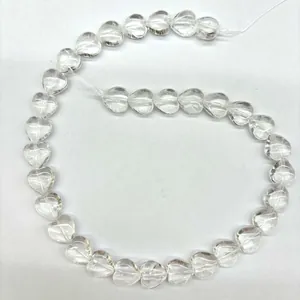 Vue macro détaillée de perles de cristal blanc en forme de cœur sur un fil blanc